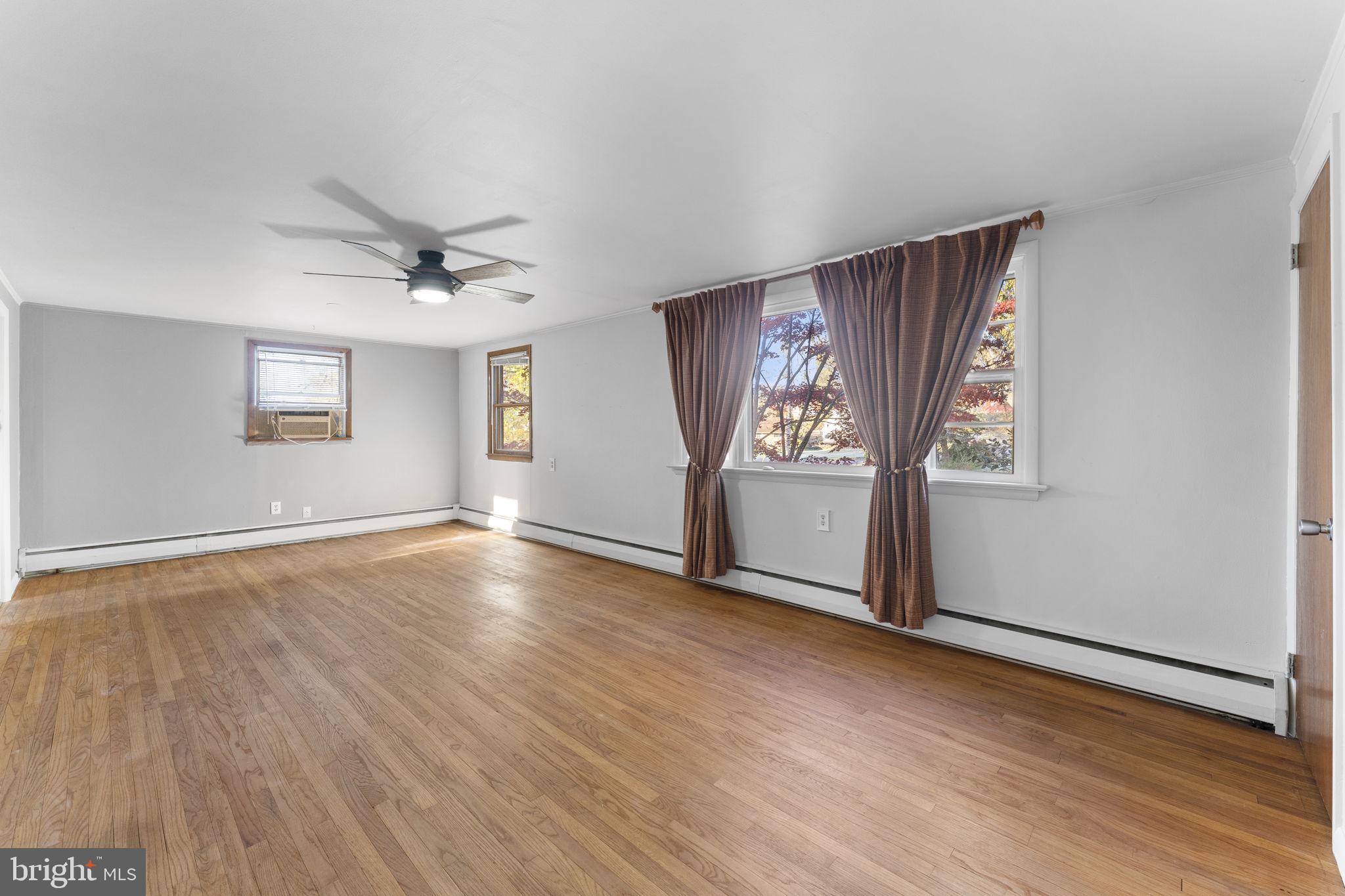 225 Pershing Avenue, Unit A Horsham, PA 19044 - Photo 6 of 19 a view of an empty room with window and wooden floor