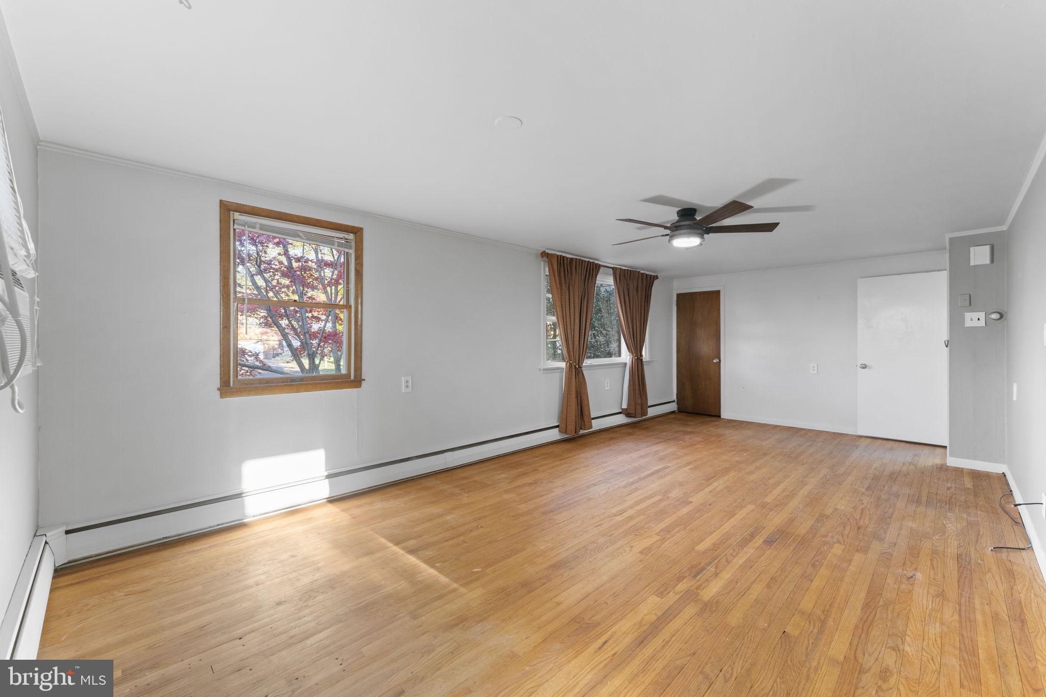 225 Pershing Avenue, Unit A Horsham, PA 19044 - Photo 7 of 19 a view of an empty room with wooden floor and a window