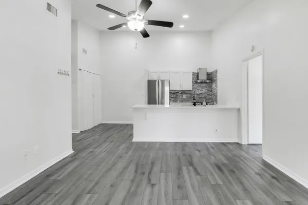 a view of a kitchen with wooden floor and a ceiling fan
