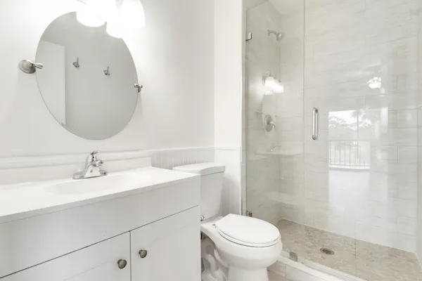 a bathroom with a sink a toilet and shower