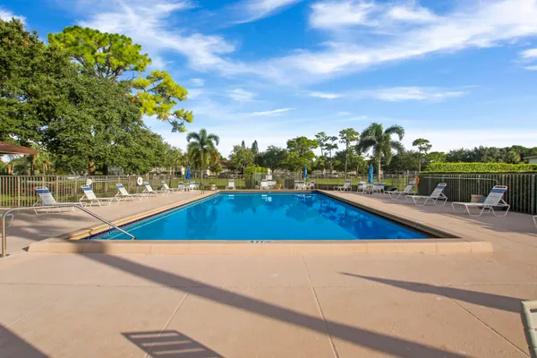 a view of a swimming pool with a patio and a yard