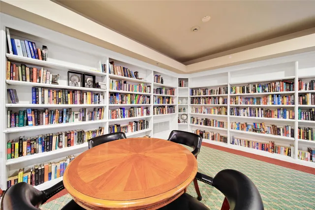 a view of a livingroom with a bookshelf and a workspace