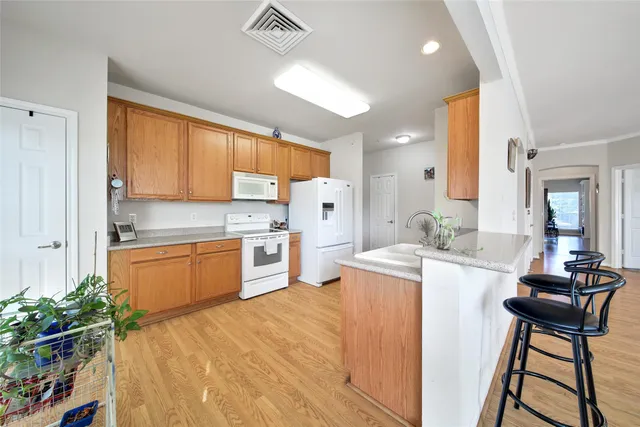 a kitchen with a table chairs refrigerator and microwave
