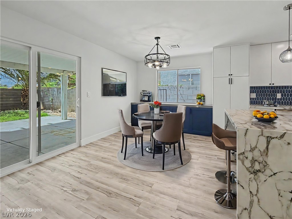 8977 Paige Rene Court Las Vegas, NV 89117 - Photo 15 of 31 Sliding glass doors offer seamless access to the outdoor living space from this bright, open-concept kitchen and dining area.