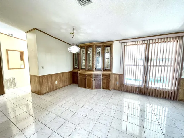 a view of a hallway with wooden floor and windows