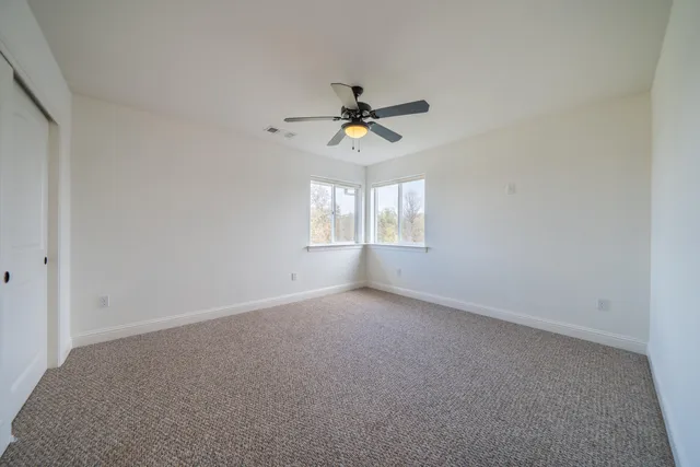 a view of a house with a big yard and large trees