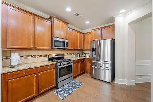 a kitchen with stainless steel appliances granite countertop a refrigerator stove microwave and sink