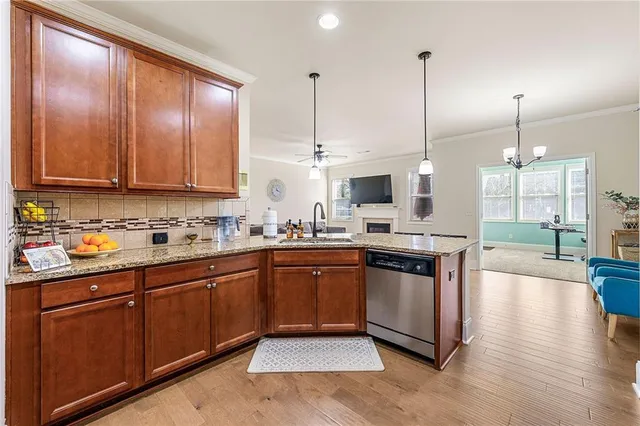 a kitchen with stainless steel appliances granite countertop wooden cabinets a sink and dishwasher