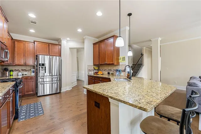 a kitchen with kitchen island granite countertop wooden cabinets and a refrigerator