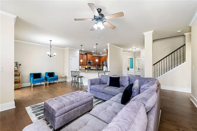 a living room with furniture kitchen view and a chandelier