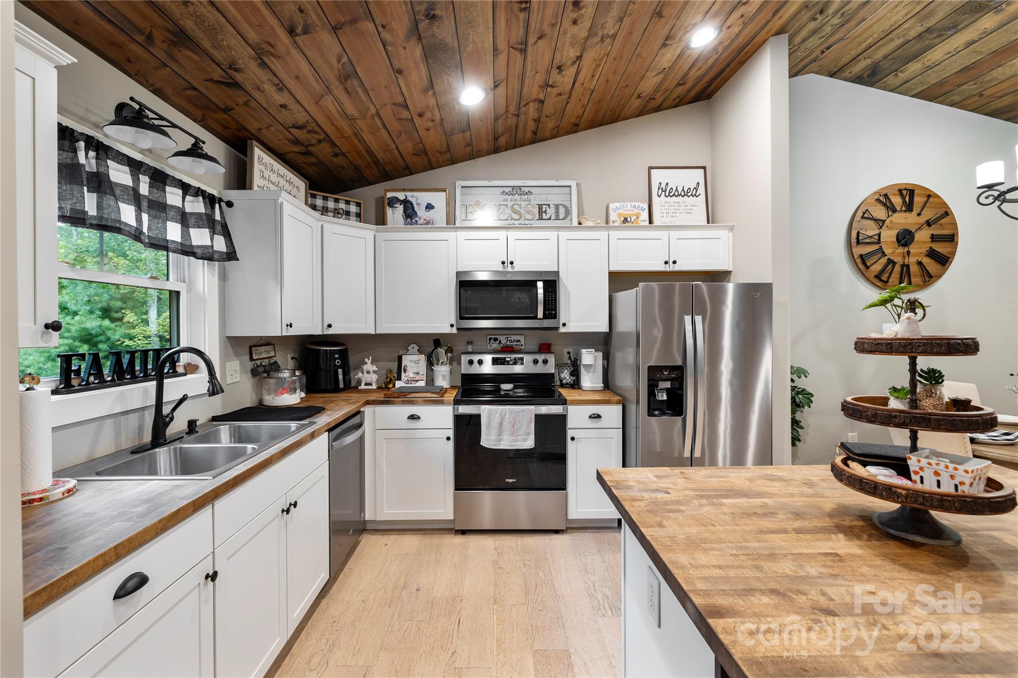 185 Ben Nevis Road Brevard, NC 28712 - Photo 11 of 42 a kitchen with stainless steel appliances granite countertop a refrigerator oven a sink dishwasher and white cabinets with wooden floor