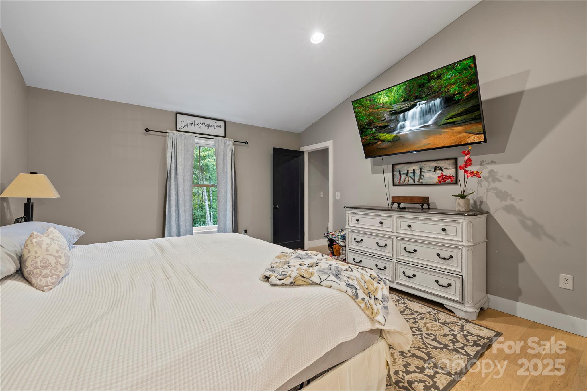 185 Ben Nevis Road Brevard, NC 28712 - Photo 17 of 42 a bedroom with a bed and a flat screen tv in it