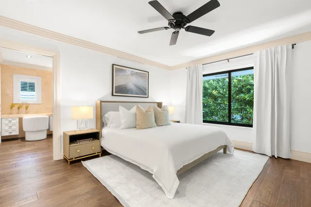 a bedroom with a large bed and a chandelier