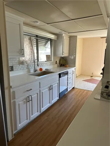 a view of a livingroom with furniture window and a kitchen