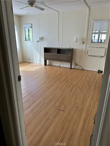 a view of a big room with wooden floor and windows