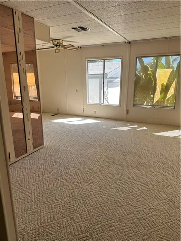 an empty room with wooden floor fireplace and windows