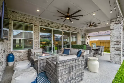 a living room with patio furniture and a large window