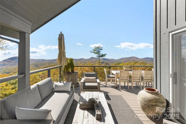 a living room with furniture floor to ceiling windows and wooden floor