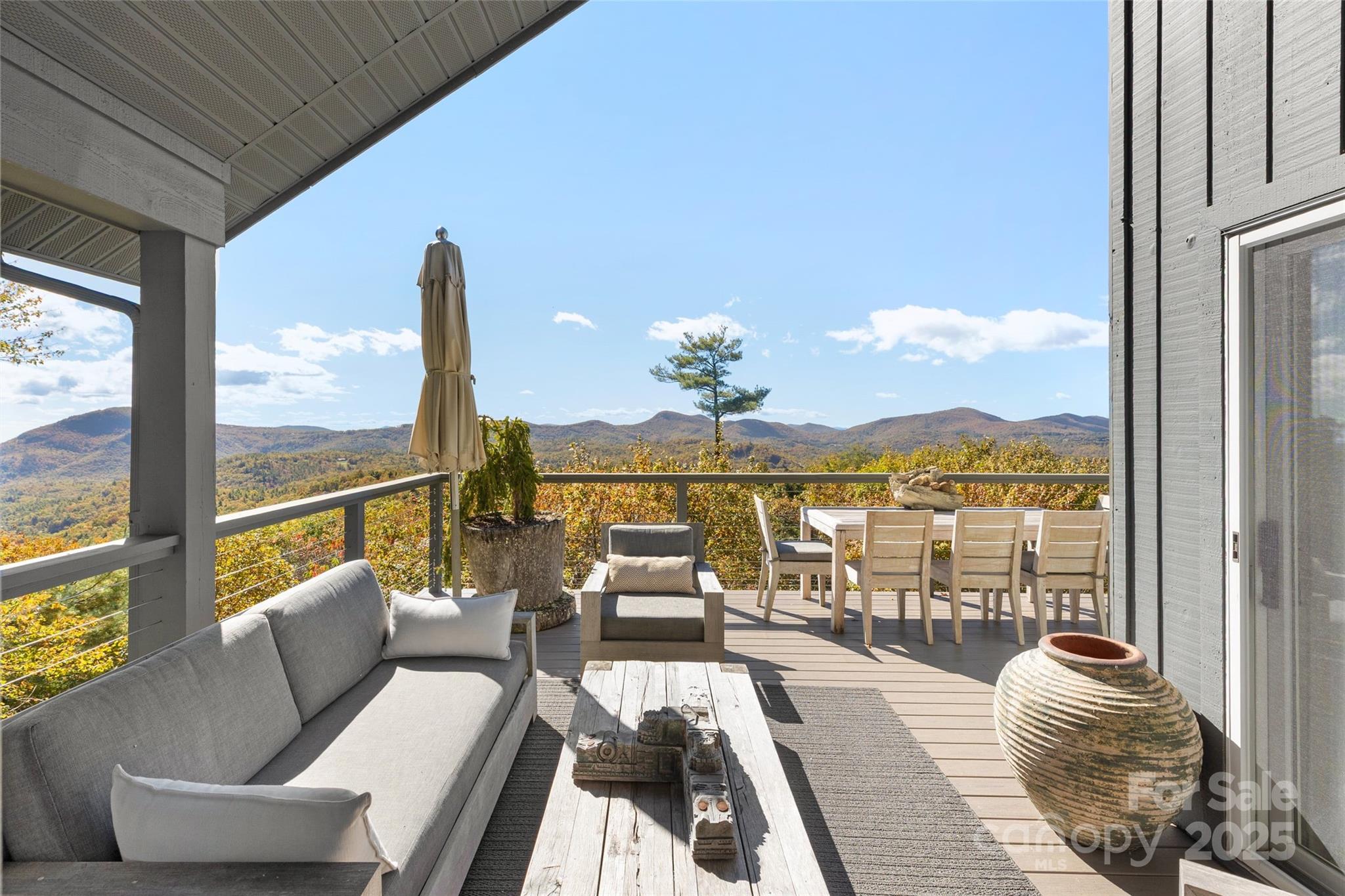 a living room with furniture floor to ceiling windows and wooden floor