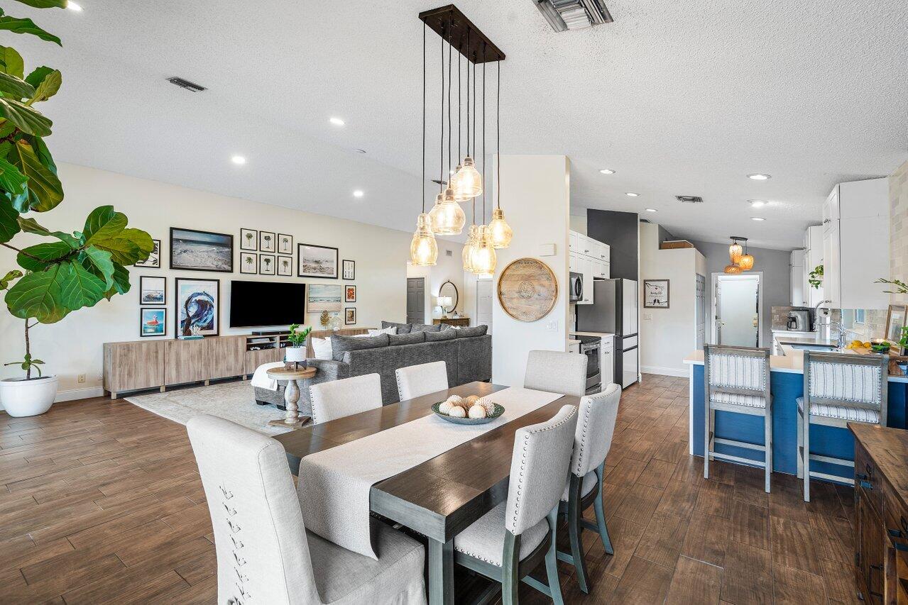 8541 Nadmar Avenue Boca Raton, FL 33434 - Photo 15 of 39 a dining room with wooden floor a glass table and chairs
