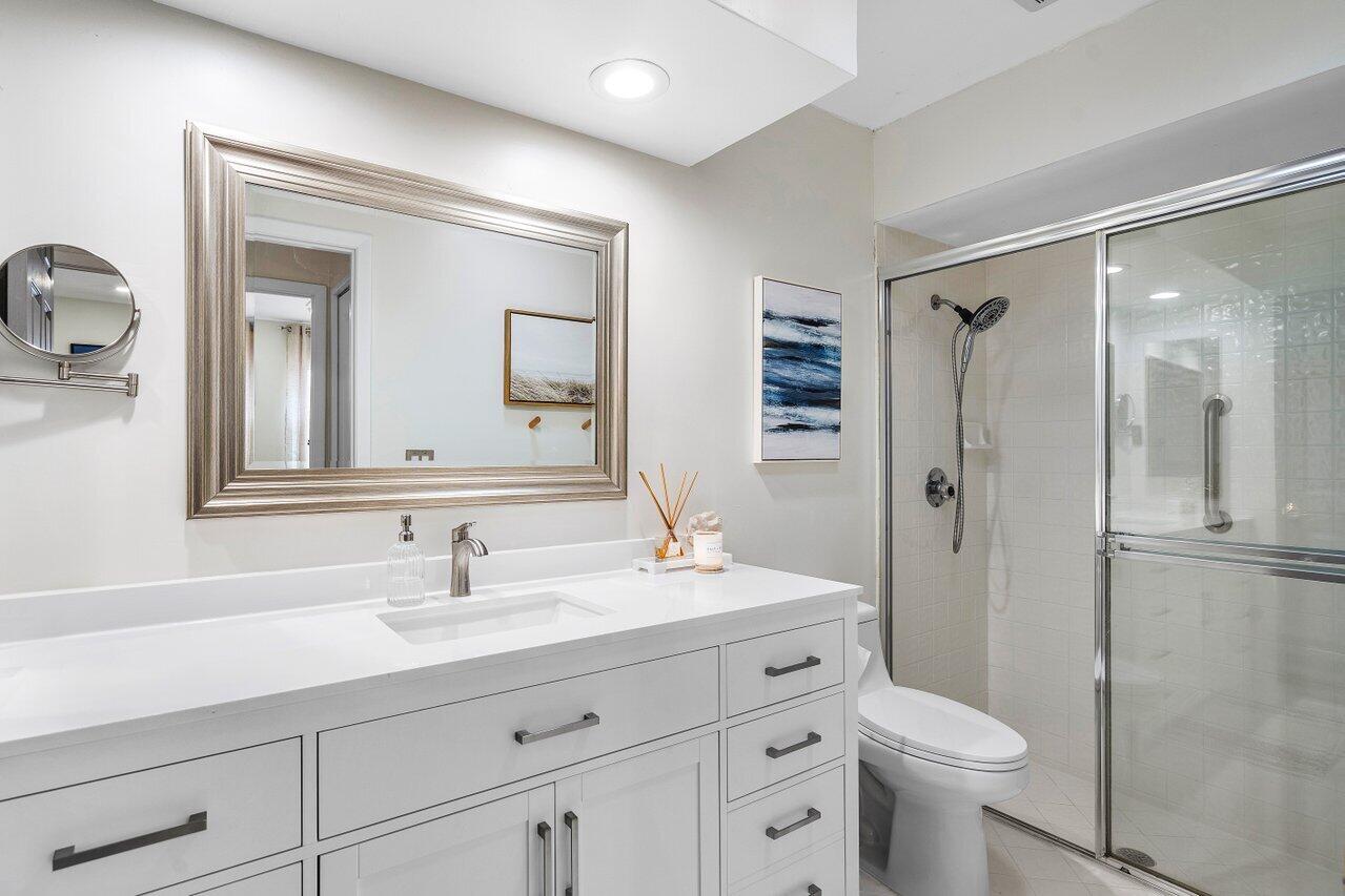 8541 Nadmar Avenue Boca Raton, FL 33434 - Photo 19 of 39 a bathroom with a sink a toilet a shower and a mirror