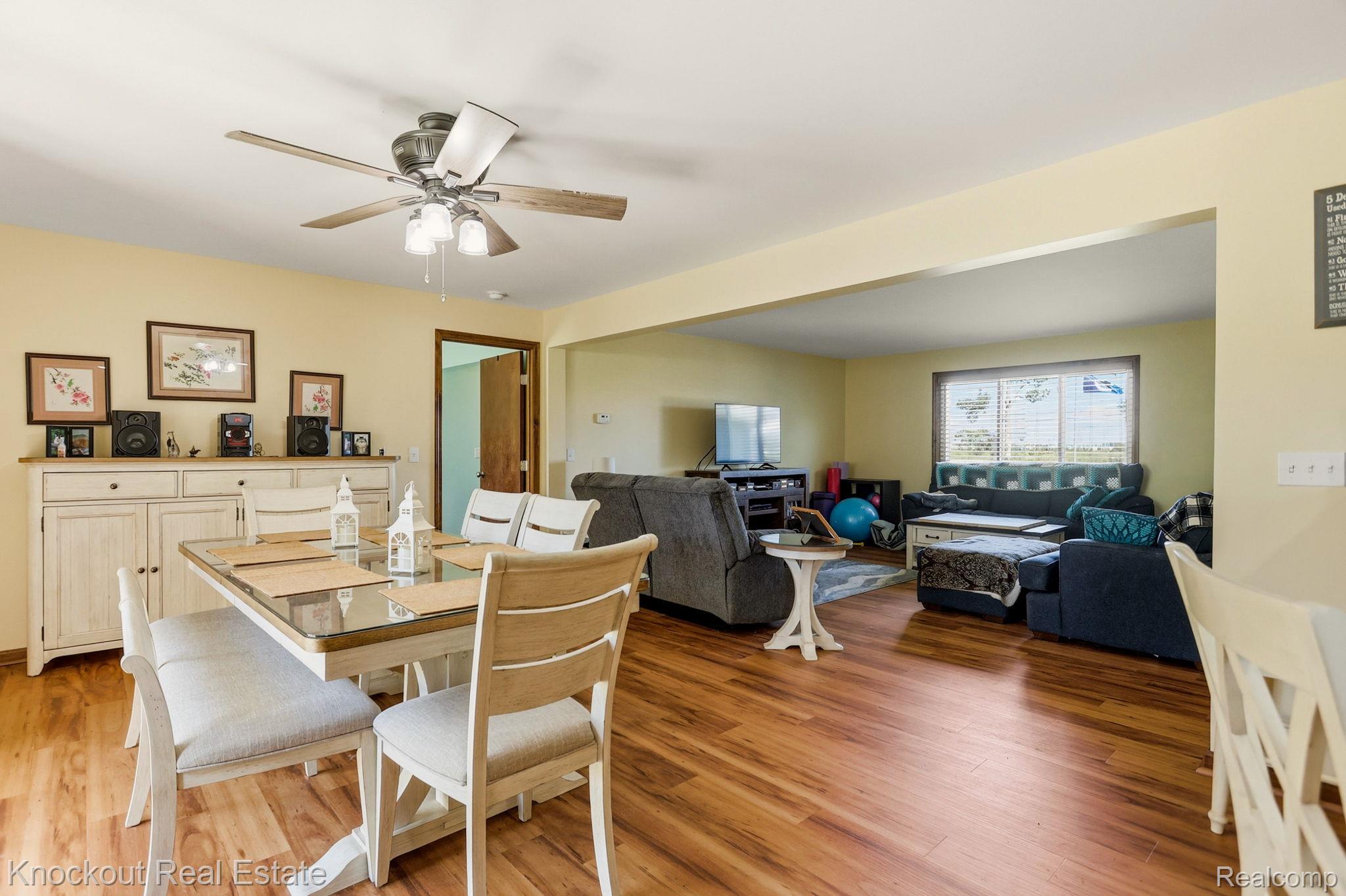 5727 Mackinaw Road Saginaw, MI 48604 - Photo 22 of 60 Wood-finish flooring throughout, a ceiling fan with integrated lighting, and an expansive doorway opening to a secondary living area
