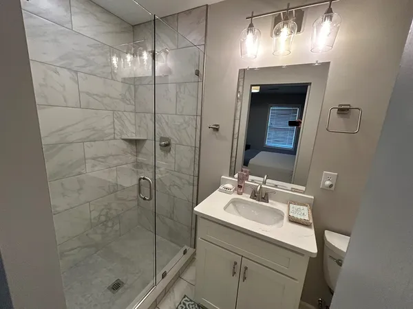 a bathroom with a sink shower and a mirror