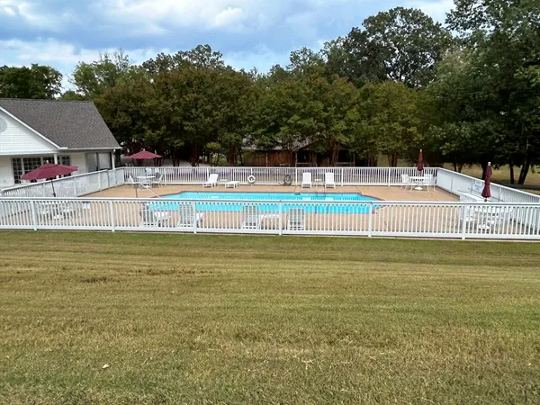 a view of a swimming pool with an outdoor seating and a yard