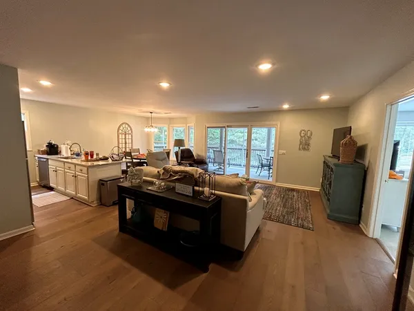 a living room with furniture a large window with kitchen view