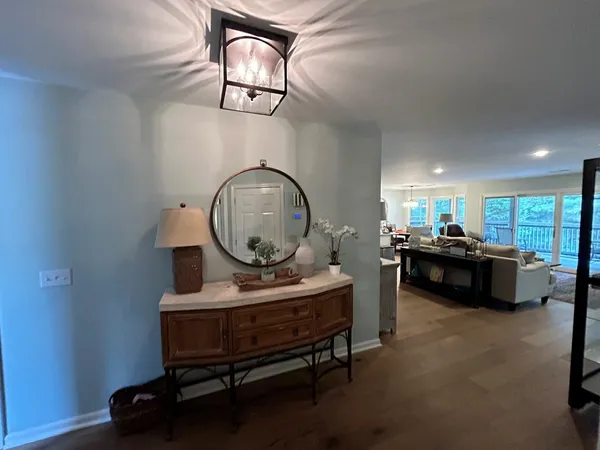 a living room with furniture a mirror and a chandelier