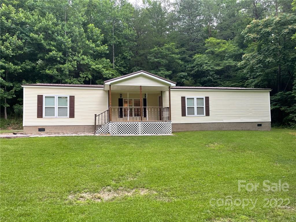 1682 Laughter Road Mill Spring, NC 28756 - Photo 1 of 24 a front view of a house with a garden