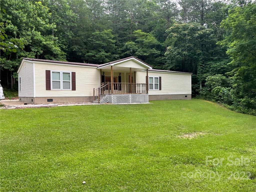 1682 Laughter Road Mill Spring, NC 28756 - Photo 2 of 24 a front view of a house with a yard and trees
