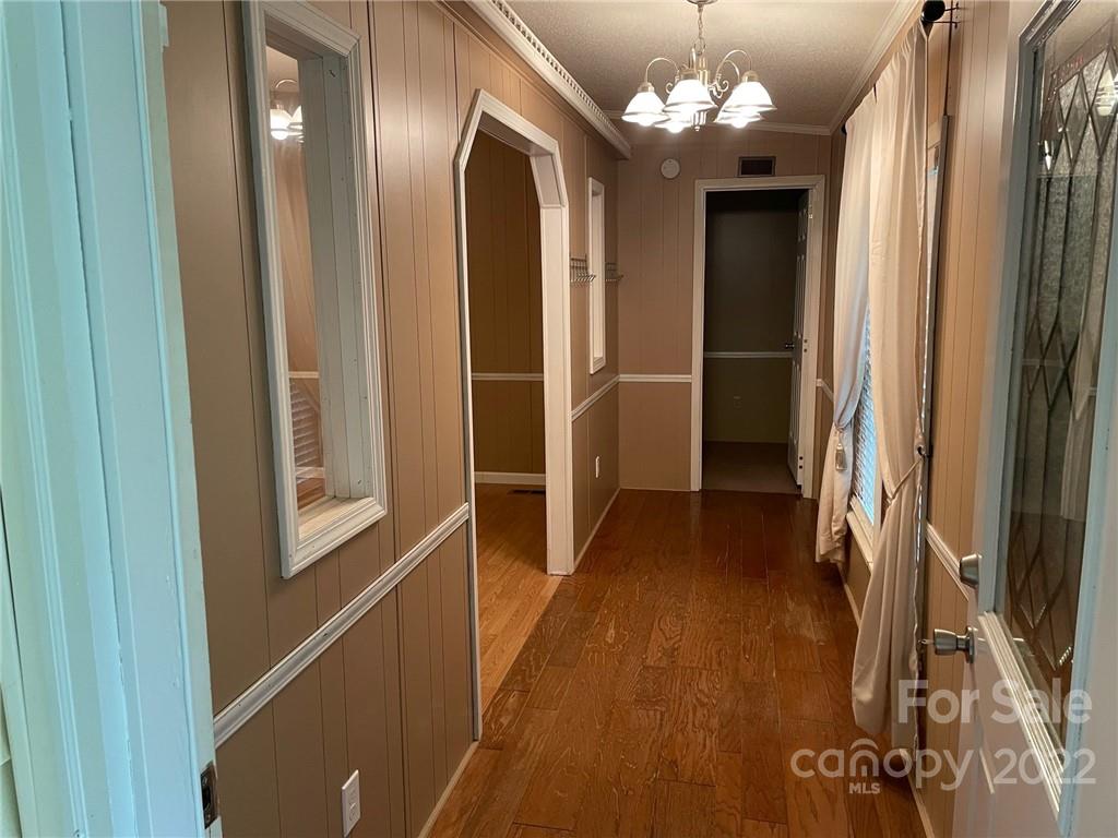 1682 Laughter Road Mill Spring, NC 28756 - Photo 8 of 24 a view of a hallway with wooden floor and chandelier