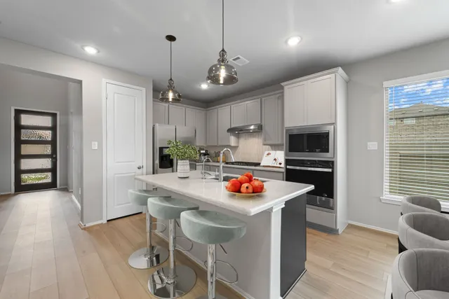 a large kitchen with stainless steel appliances granite countertop a lot of counter space and wooden floor