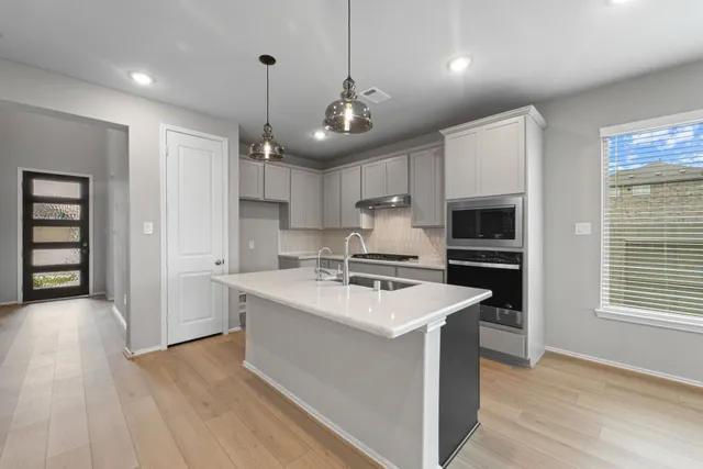 a view of a hallway with wooden floor and a ceiling fan