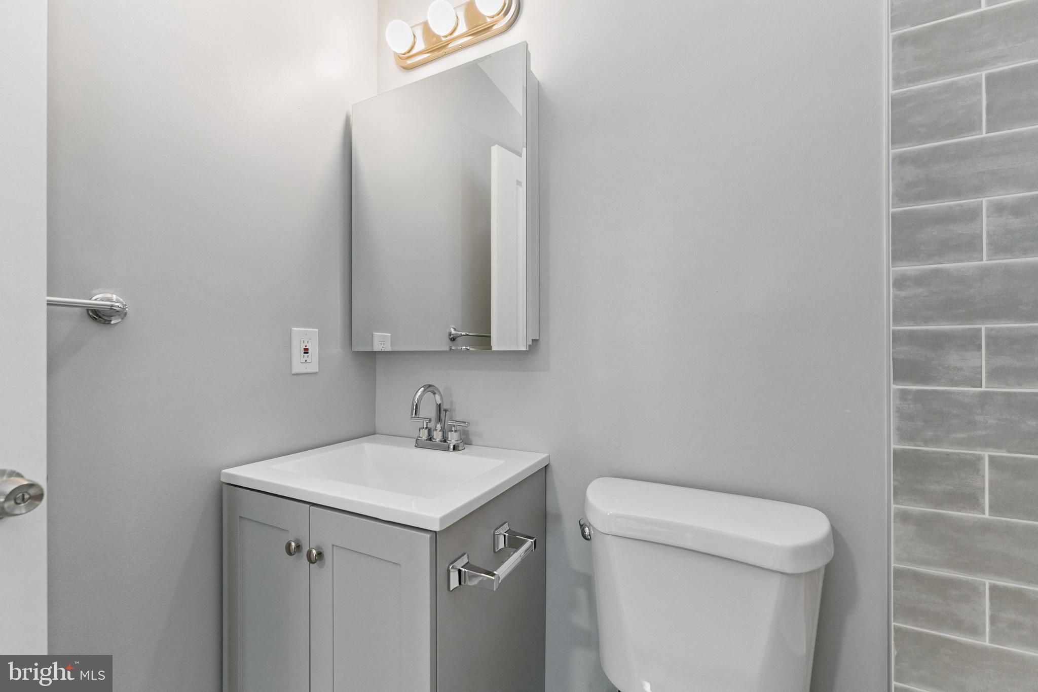 2021 E Street Northeast, Unit 4 Washington, DC 20002 - Photo 12 of 15 a view of bathroom with a toilet sink and mirror