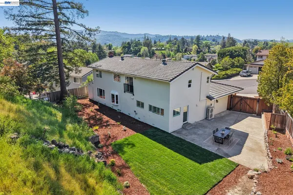an aerial view of a house with yard and mountain view in back