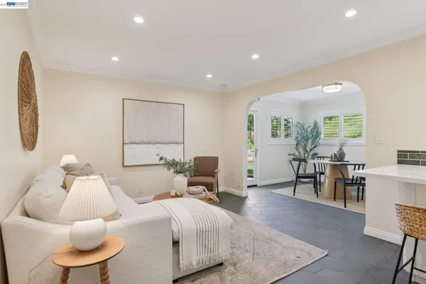a living room with furniture kitchen view and a large window