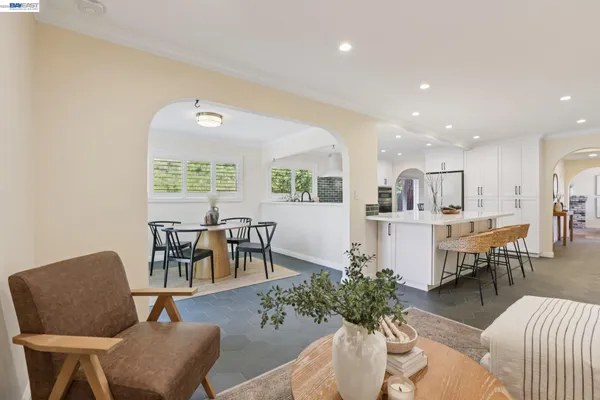 a kitchen with stainless steel appliances kitchen island granite countertop a stove a sink a dining table and chairs