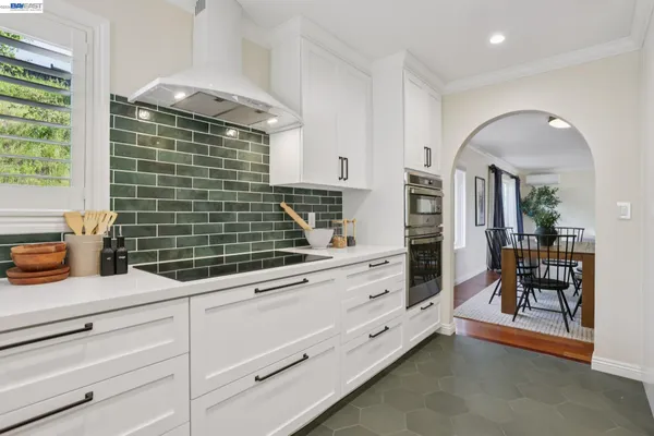 a large kitchen with stainless steel appliances kitchen island granite countertop a table and chairs in it