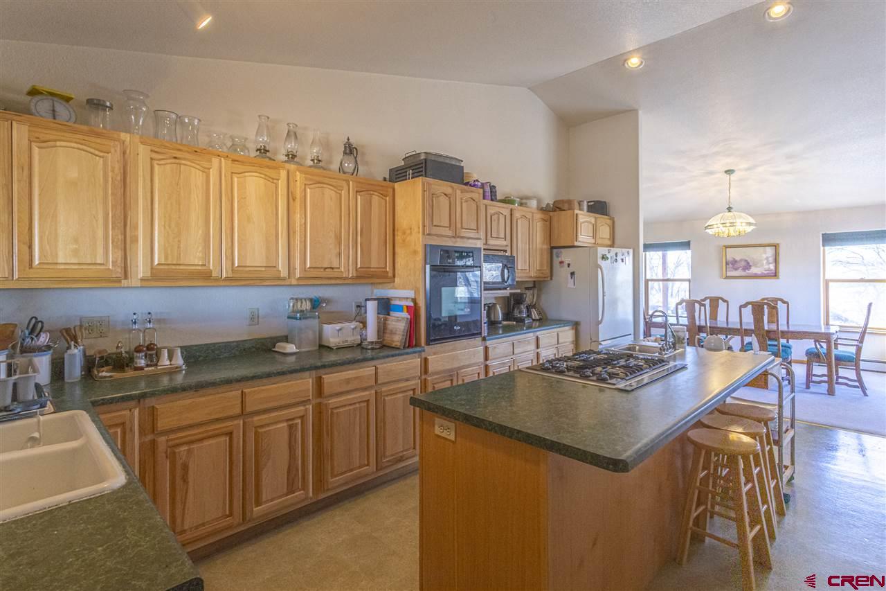 959 1200th Road Delta, CO 81416 - Photo 22 of 34 a kitchen with stainless steel appliances granite countertop a sink a stove and cabinets