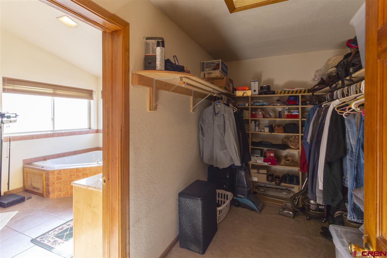 959 1200th Road Delta, CO 81416 - Photo 8 of 34 a view of walk in closet with clothes and shoes