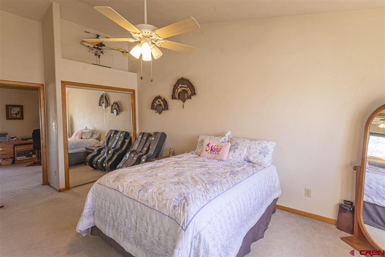 959 1200th Road Delta, CO 81416 - Photo 10 of 34 a bedroom with a bed and a chandelier