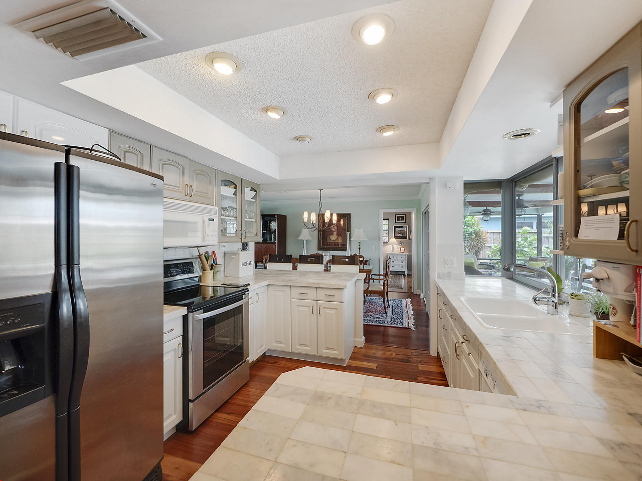 99 Golfview Drive Tequesta, FL 33469 - Photo 7 of 17 a kitchen with stainless steel appliances granite countertop a refrigerator and a sink