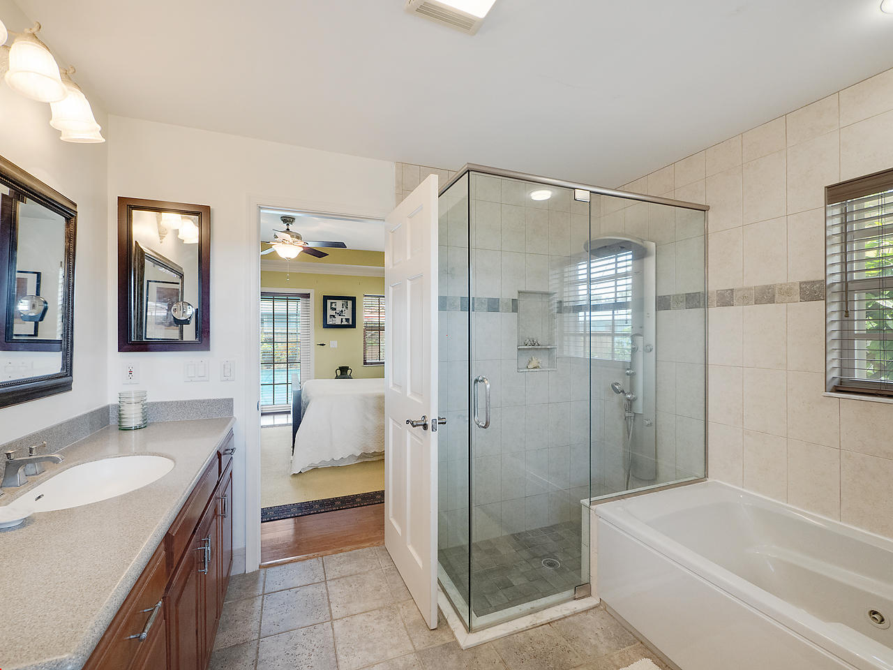 99 Golfview Drive Tequesta, FL 33469 - Photo 10 of 17 a bathroom with a tub shower sink and mirror