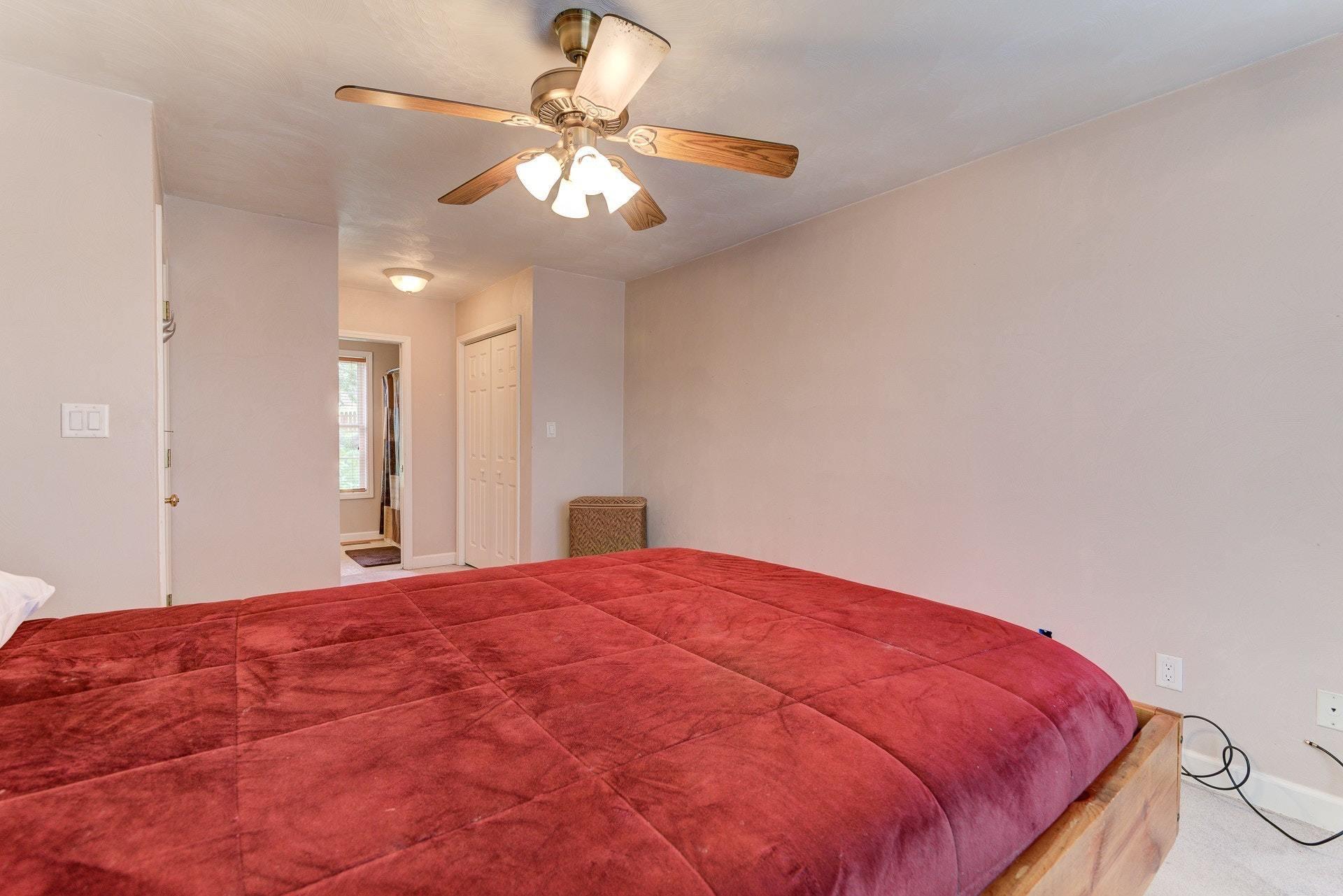 1744 Meadows Road Vinton, VA 24179 - Photo 15 of 36 a view of a bedroom with a large bed and chandelier fan