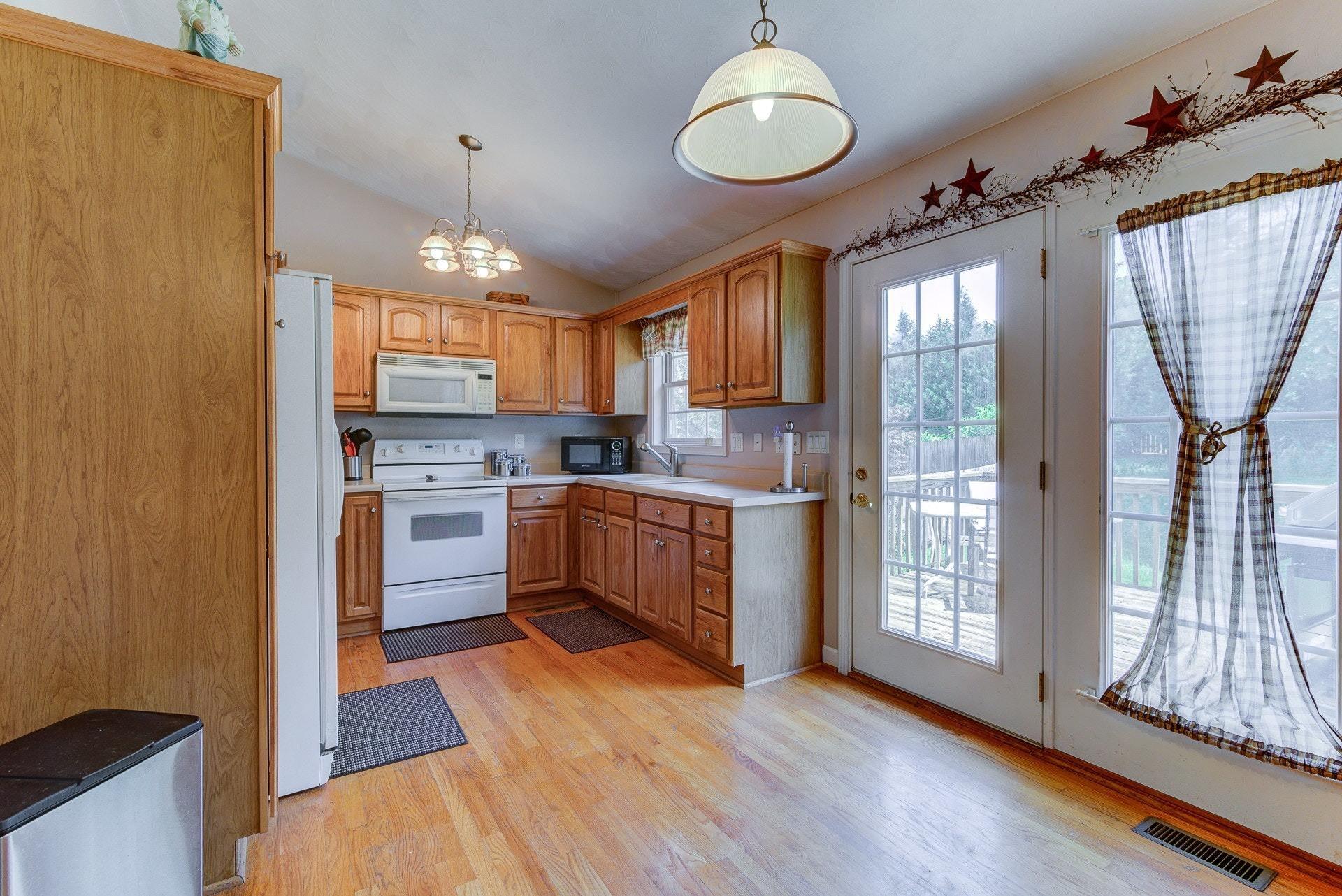 1744 Meadows Road Vinton, VA 24179 - Photo 8 of 36 a kitchen with stainless steel appliances granite countertop a refrigerator a sink dishwasher a stove and a dining table with wooden floor
