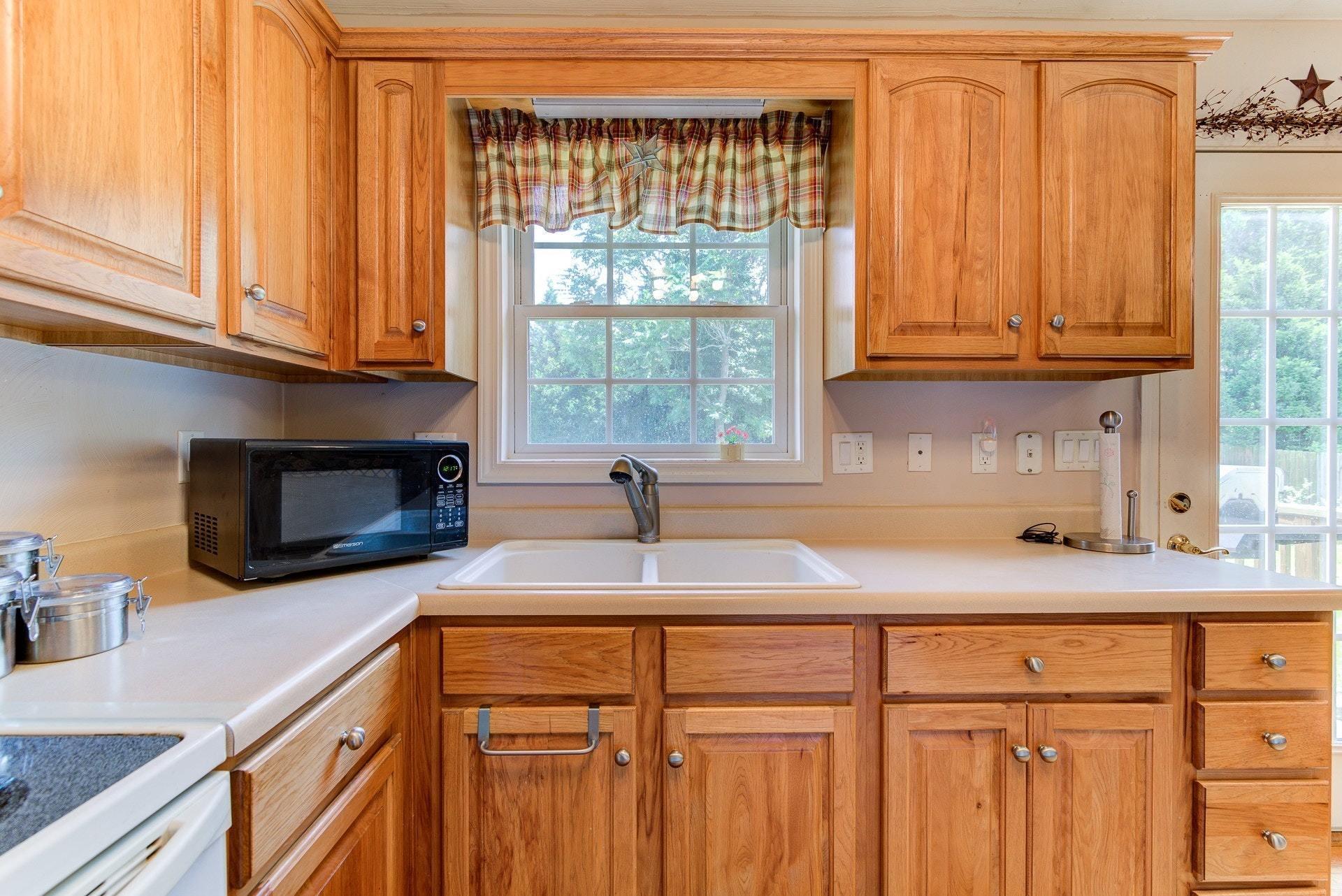 1744 Meadows Road Vinton, VA 24179 - Photo 10 of 36 a kitchen with granite countertop a sink a window stainless steel appliances and cabinets