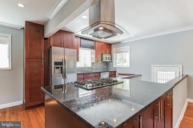 a kitchen with stainless steel appliances granite countertop a sink stove and refrigerator