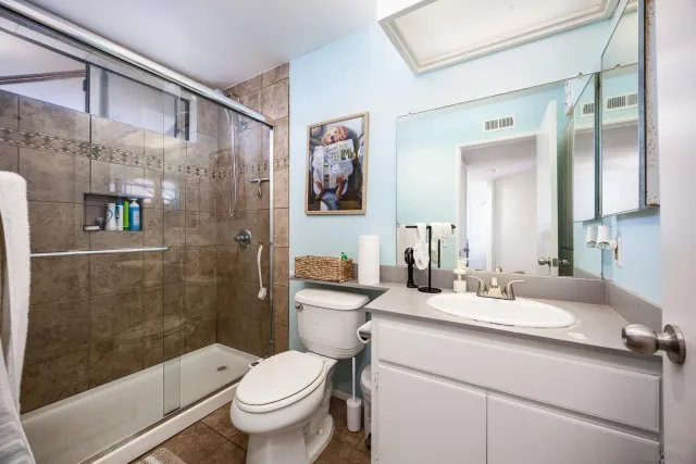 a bathroom with a sink a toilet and shower